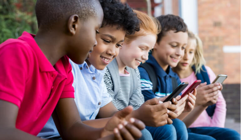 Group of kids using smartphones