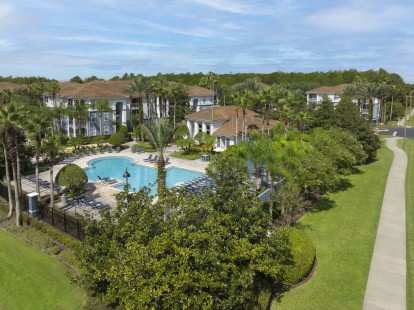 Community pool with lush landscaping at Camden World Gateway apartment community in Orlando, FL