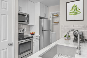 Renovated apartment homes with white quartz countertops, white shaker cabinets, and stainless steel appliances.
