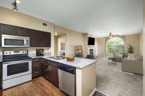 Open-concept kitchen with stainless steel appliances near living room