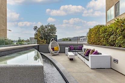 Outdoor resident lounge seating with a water feature and a view of los angeles