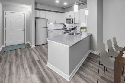 Contemporary midrise apartment kitchen with granite countertops and pendant lighting