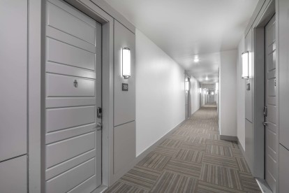 Third floor Villas side hallway with interior-facing front doors at Camden Greenville