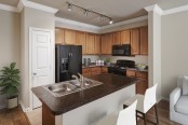 Kitchen with dark countertops and island at Camden Shadow Brook