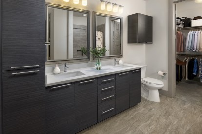 Bathroom with two sinks, linen storage and a large walk-in closet