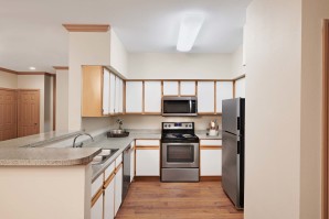Open and expansive kitchen with stainless steel appliances and wood style flooring