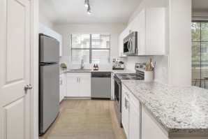 Kitchen with stainless steel appliances, quartz countertops, and white cabinetry