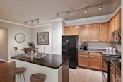 First floor kitchen with island and tile flooring at Camden Shadow Brook in Austin, TX