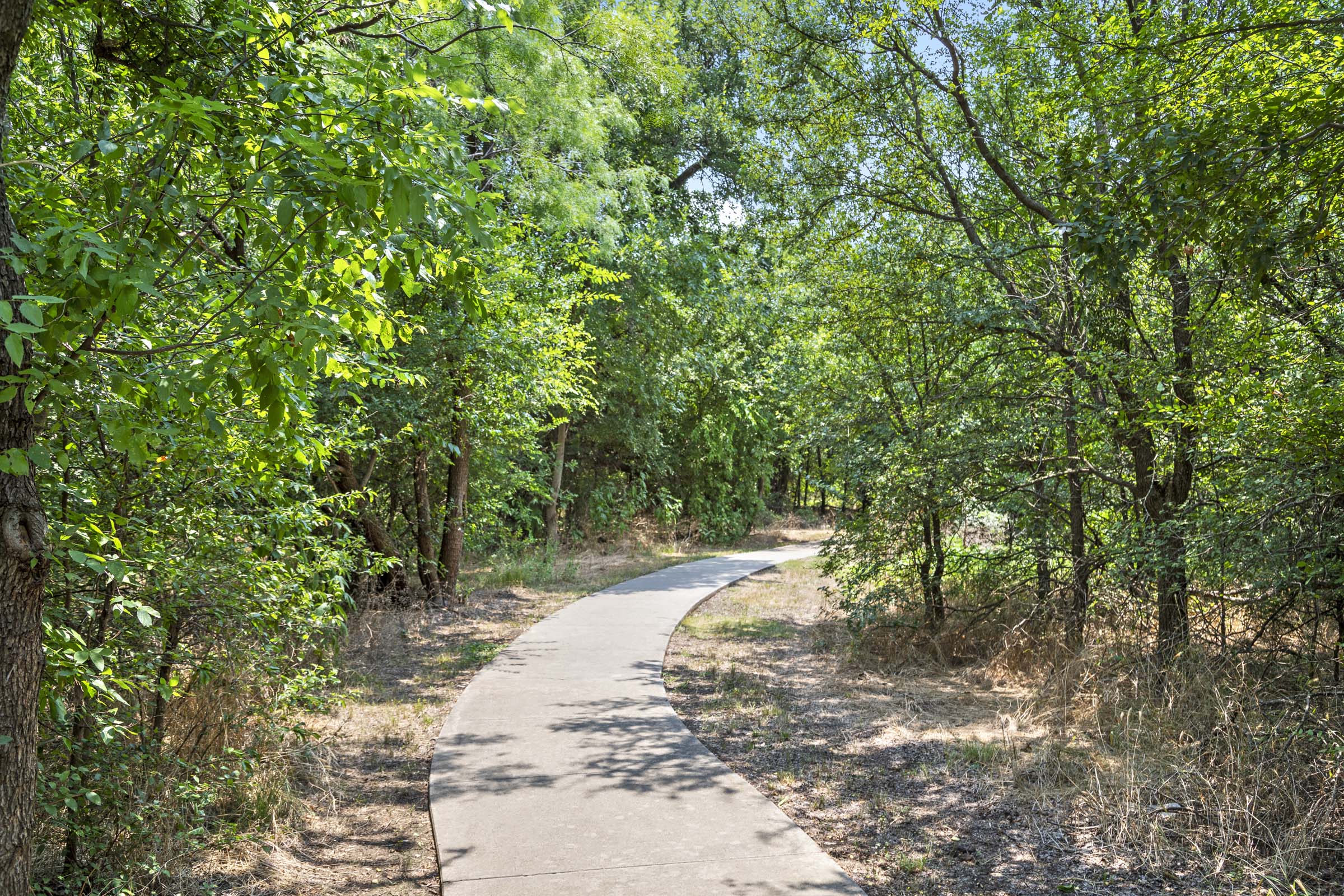 Walking trail connected to the community surrounded by wooded greenspace
