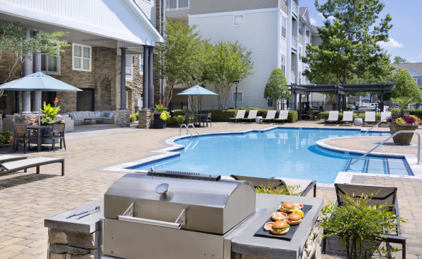 Pool with BBQ grills and dining tables at Camden Crest apartments in Raleigh, NC