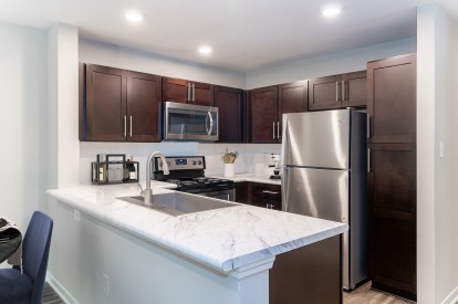 Modern style kitchen with espresso cabinets at Camden Reunion Park