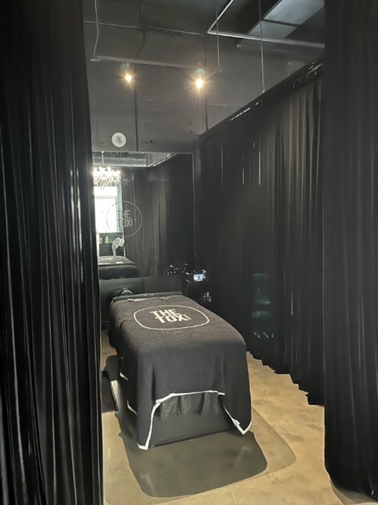 The TOX technique treatment room with curtains, a spa bed and soft lighting
