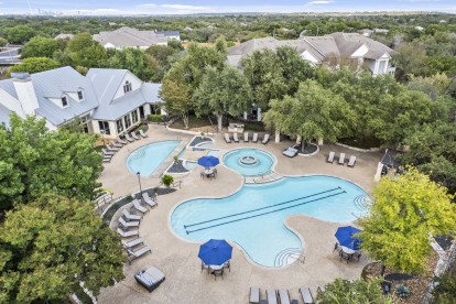 Aerial view of resort-style pool and deck behind the clubhouse at Camden Stoneleigh apartments in Austin, TX