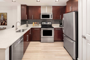 Warm modern style features an open-concept kitchen and dining space at Camden NoMa apartments in Washington, D.C.