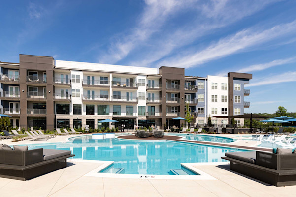 Resort-style pool with seating and deck in the middle with a firepit at Camden West Nashville apartments in Nashville, TN