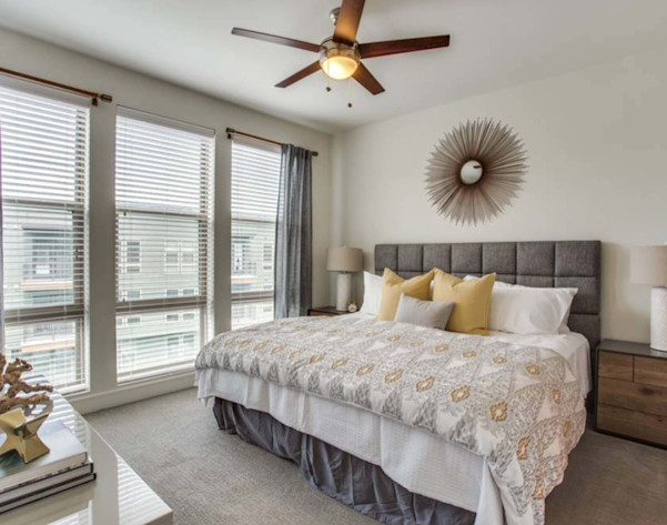 Bedroom with large windows and ceiling fan