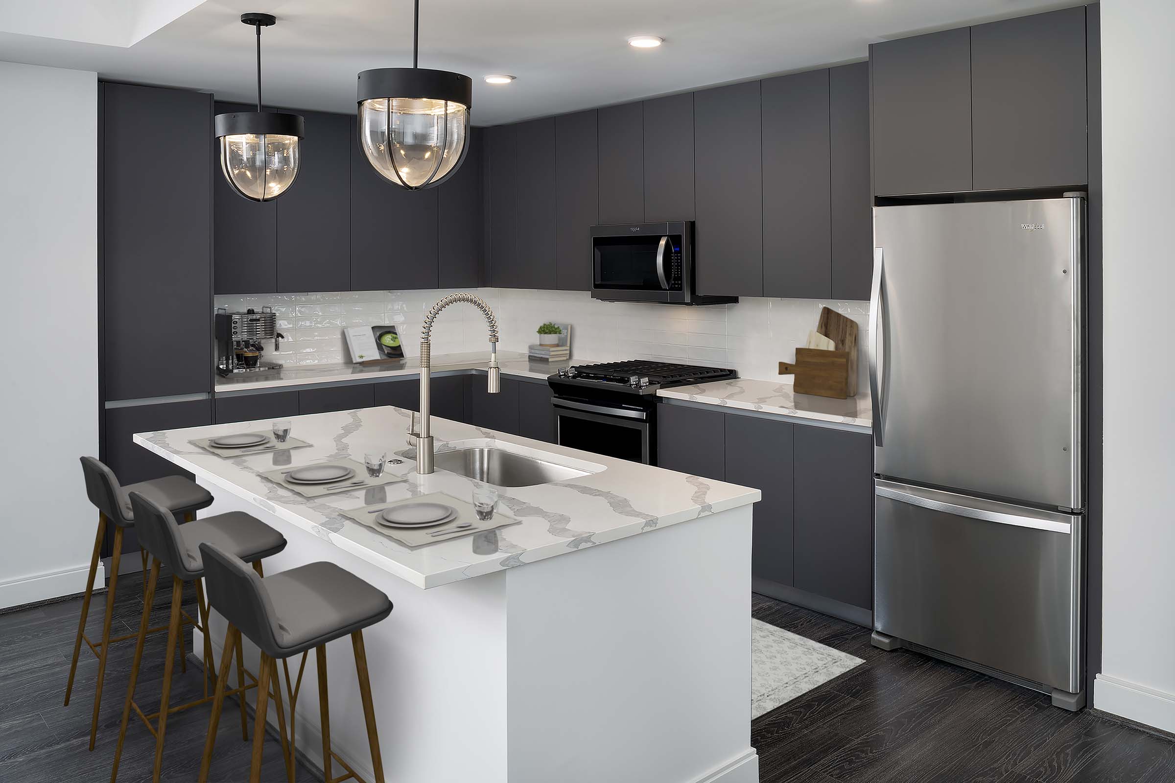 Modern gray kitchen with white quartz countertops, gray soft-close cabinets and hardwood-style flooring