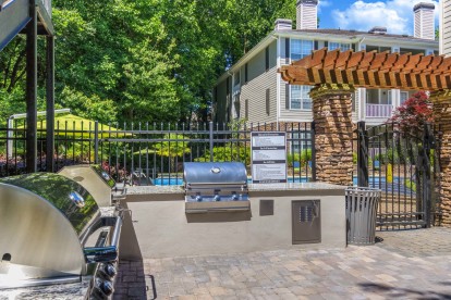 Grilling area with multiple grills and ample seating adjacent to the pool deck