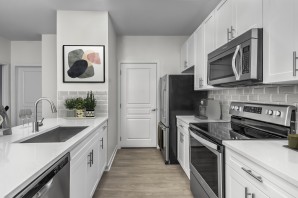 Kitchen with stainless steel appliances and gray subway backsplash