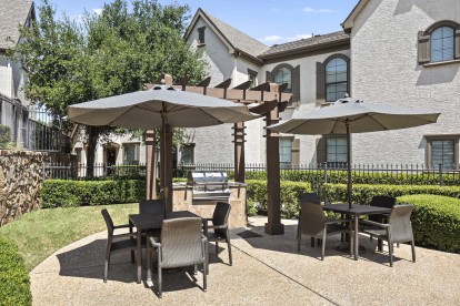 Poolside grills and tables with umbrellas at Camden Brushy Creek apartments in Austin, TX