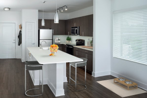 White quartz finishes in kitchen with stainless steel appliances and spacius island