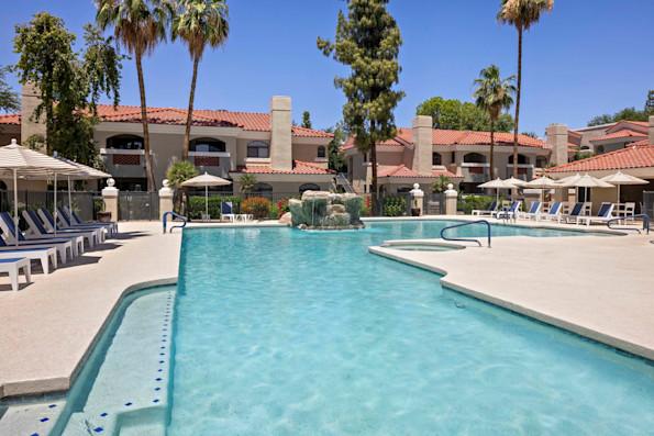 Resort-style pool with lounge chairs and umbrellas at Camden San Paloma apartments in Scottsdale, AZ