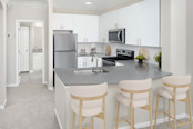 Kitchen with white cabinets stainless steel appliances and quartz countertops at Camden Deerfield in Alpharetta GA