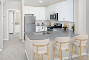 Kitchen with white cabinets stainless steel appliances and quartz countertops at Camden Deerfield in Alpharetta GA