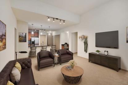 Open concept living with high ceilings track lighting and carpet flooring