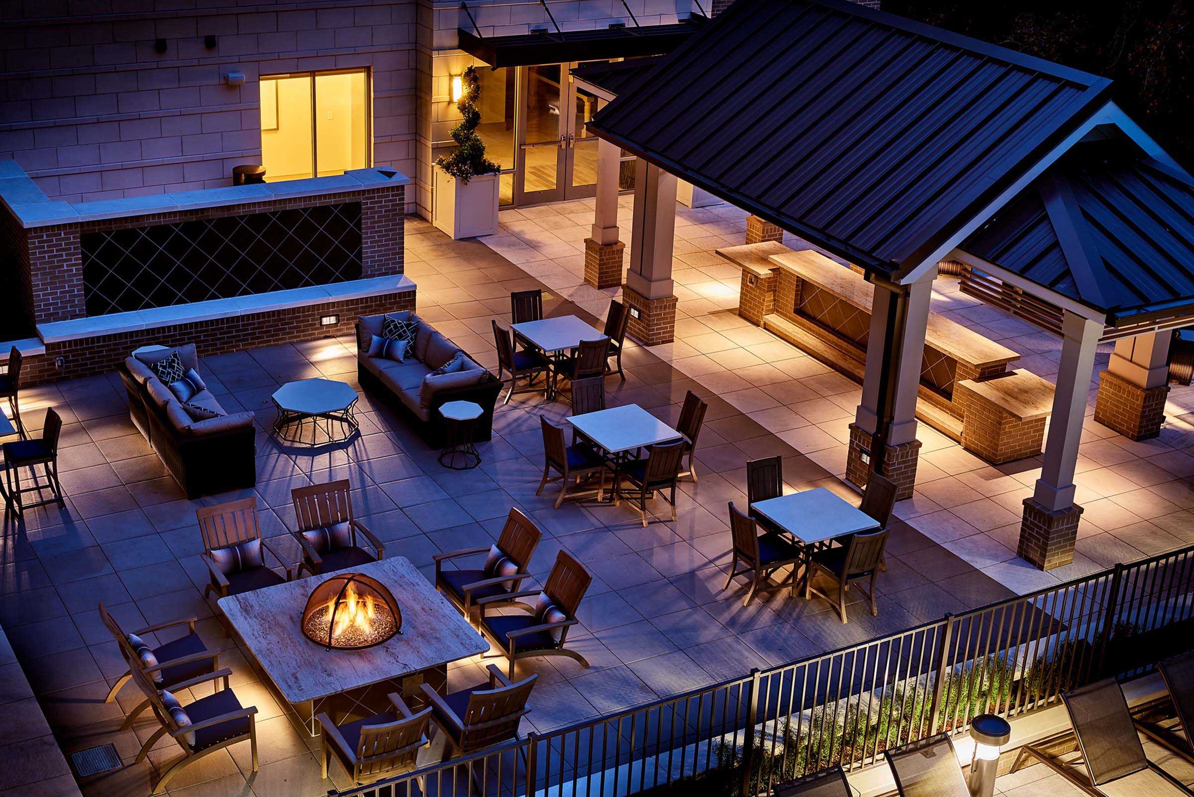 Outdoor lounge with fire pits and grills nighttime view