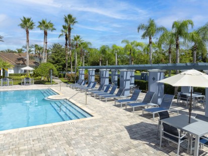 Poolside seating and lounge chairs at Camden World Gateway apartment community in Orlando, FL