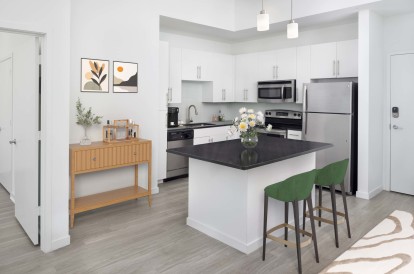 Kitchen in the white finish style with stainless steel appliances at Camden Thornton Park apartments in Orlando, FL