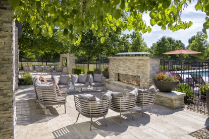 Poolside lounge with fireplace and tv at Camden Franklin Park apartments in Franklin, TN