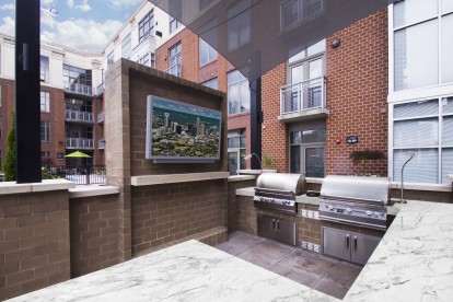 Rooftop outdoor lounge with barbeques dining areas and tvs