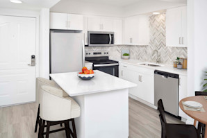 White contemporary kitchen with white quartz countertops and herringbone backsplash at Camden Grandview in Charlotte, NC