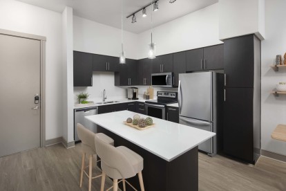 Modern-style kitchen with white countertops and brown cabinets at Camden Belmont apartments in Dallas, Tx