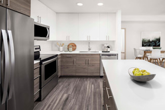 Spacious kitchen with stainless steel appliances, white quartz countertops, and white subway tile backsplash at Camden Potomac Yard Apartments in Arlington, VA