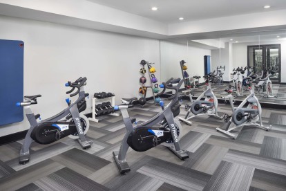 Separate spin and yoga room with spin bikes and strength equipment at Camden Design District apartments in Dallas, TX