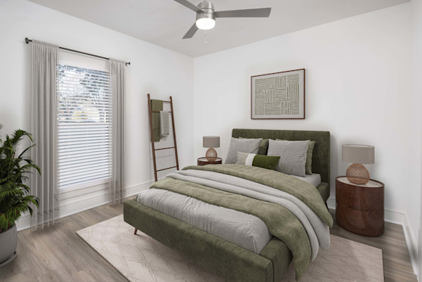 Townhome first-floor bedroom with wood-style floors, ceiling fan, and ensuite bathroom at Camden Belmont apartments in Dallas, TX