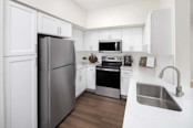 Kitchen with white quartz countertops and white shaker cabinets at Camden Centreport apartments in Fort Worth, TX