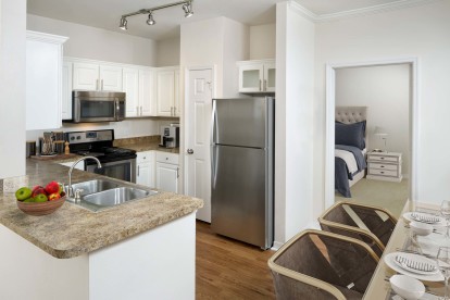 Kitchen with stainless steel appliances and large pantry at Camden Lago Vista apartments in Orlando, FL