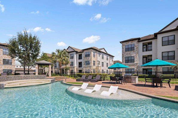Resort-style pool with tanning shelf grills and dining areas