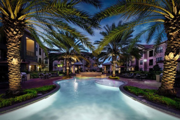 Beach style pool with tanning shelf grills and dining areas