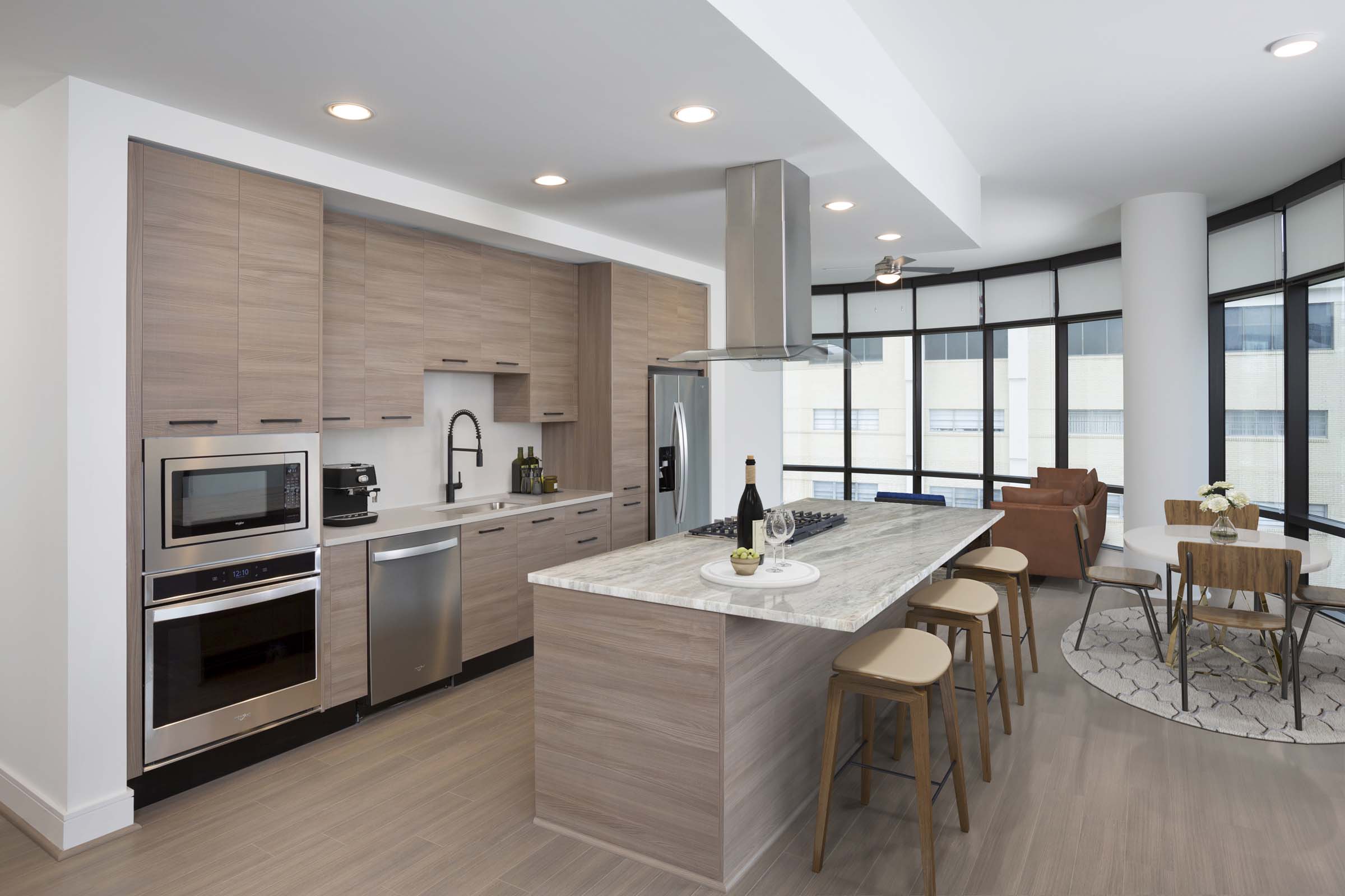 Warm modern finishes in kitchen with gas range quartz countertops and vent hood