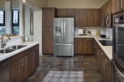 Kitchen with quartz countertops double ovens tile flooring and stainless steel appliances