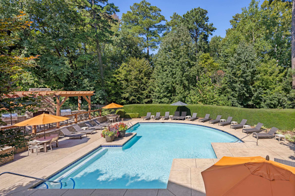 Large seasonal pool with seating and tables with tents for outdoor dining at Camden Overlook apartments in Raleigh, NC. 
