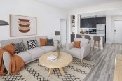 Open-concept kitchen and living room with wood-look flooring at Camden North Quarter apartments in Orlando, FL