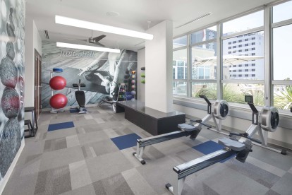 Yoga area and rowing machines in the 24-hour fitness center at Camden Rainey Street