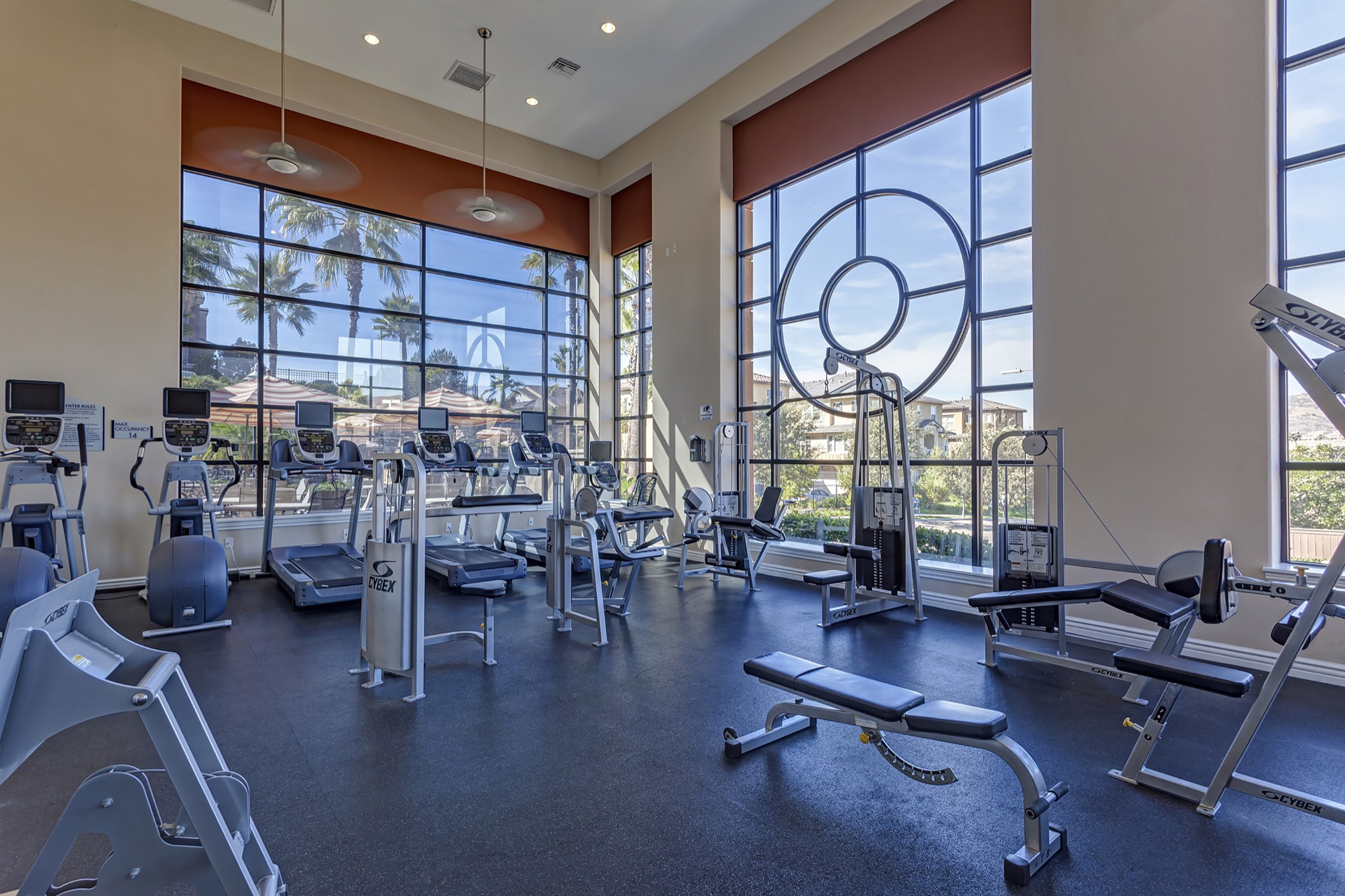 Well-lit fitness center with cardio and strength training equipment 