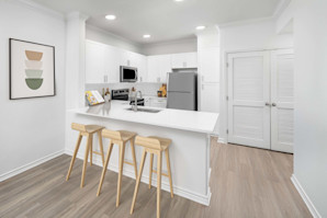 Kitchen with white quartz countertops and breakfast bar at Camden Northpointe Apartments in Tomball, Tx